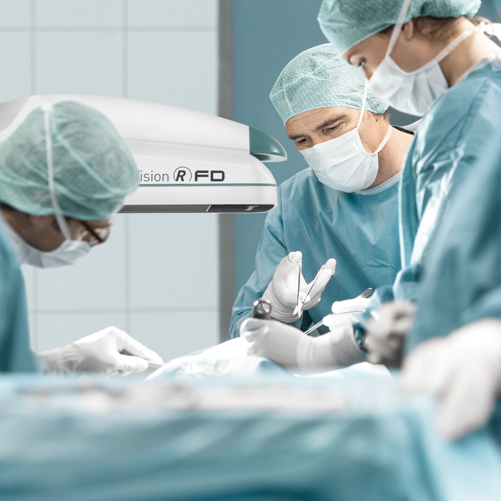 Surgeons using Ziehm Flat panel mobile C-arm during surgical procedure.